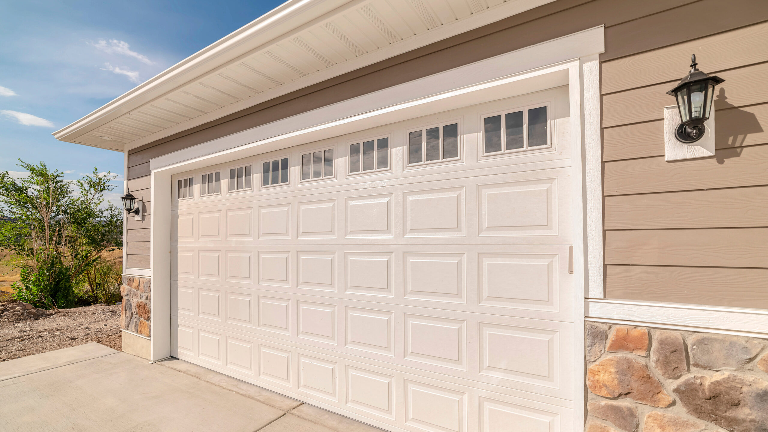 Panorama frame Double garage of modern home on sunny, clear day. A double garage and driveway of a modern home on a sunny, clear day.